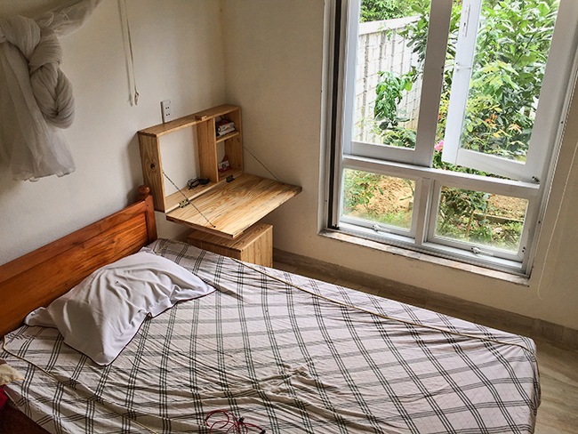 The room with a bed, table and chair and it features a hammock!